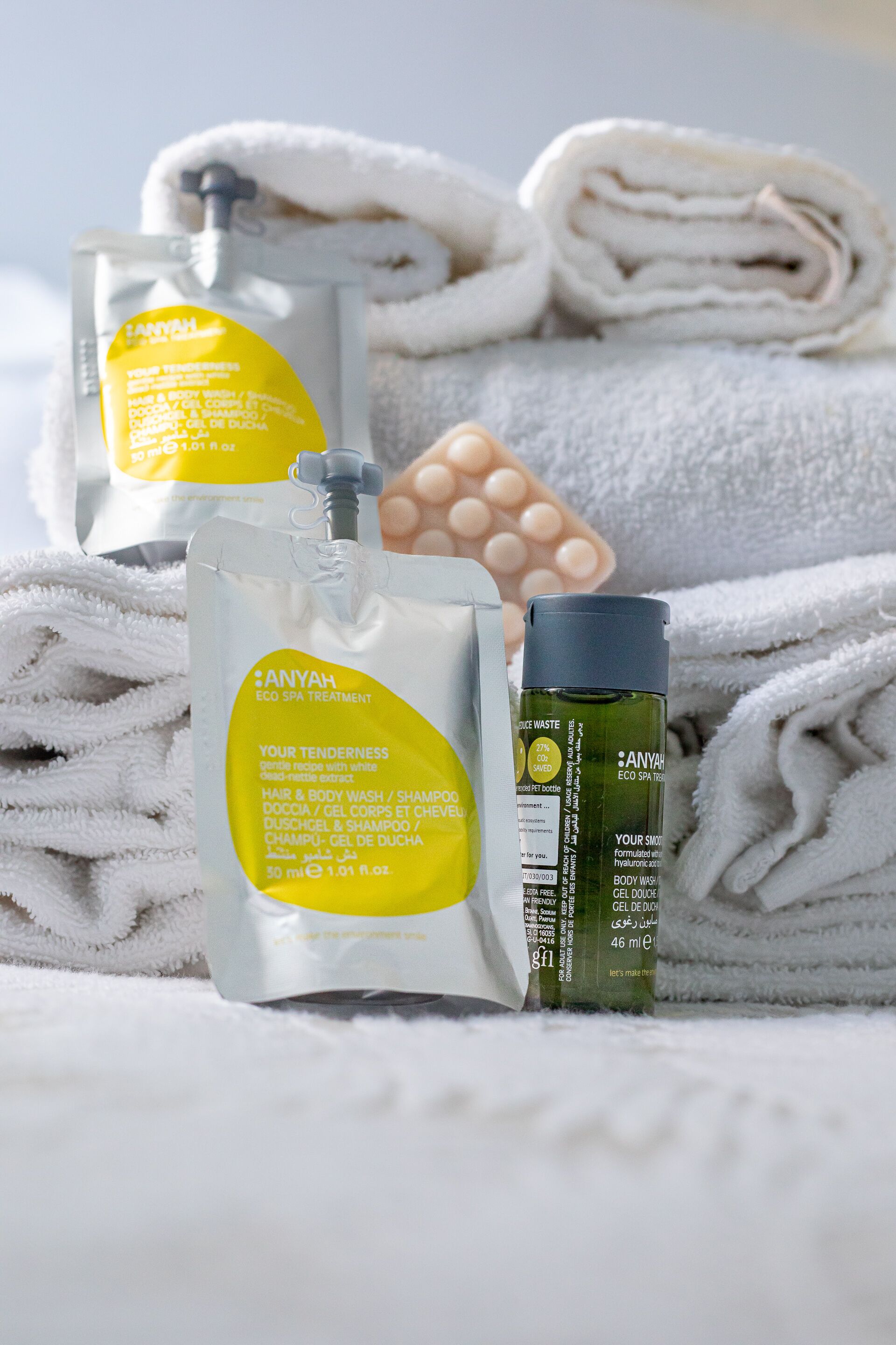 A bathroom with toiletries including a bottle of shampoo, a bottle of body wash, and a bar of soap.