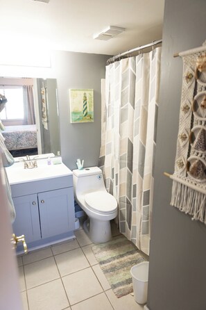 Tina con regadera, secadora de cabello, toallas, jabón 