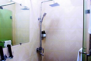 Standaard kamer | Badkamer | Een douche, een haardroger, handdoeken, zeep