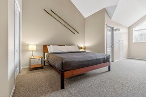 A bedroom with a bed, bedside lamps, a door, and a window. - 5 Mins to the Resort & Fernie. On the Elk River (Fernie)