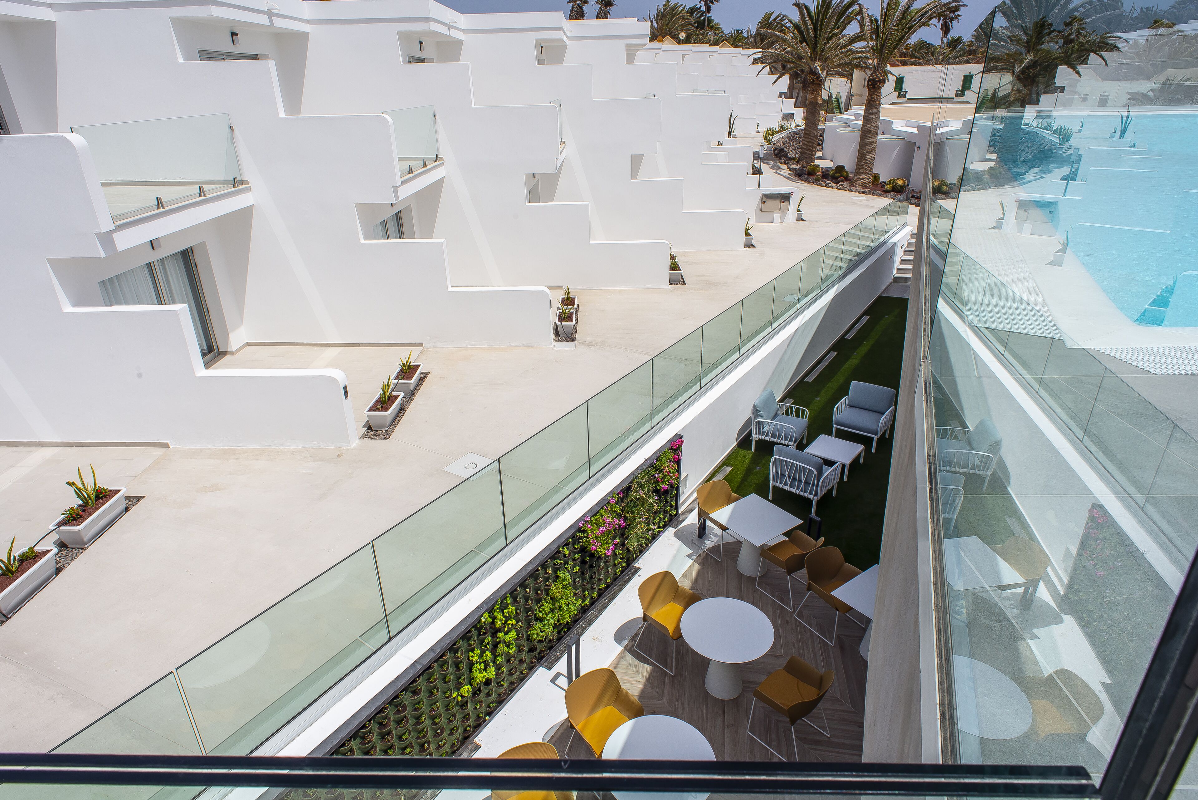 A rooftop terrace with a pool, outdoor seating, and a view of the pool area.