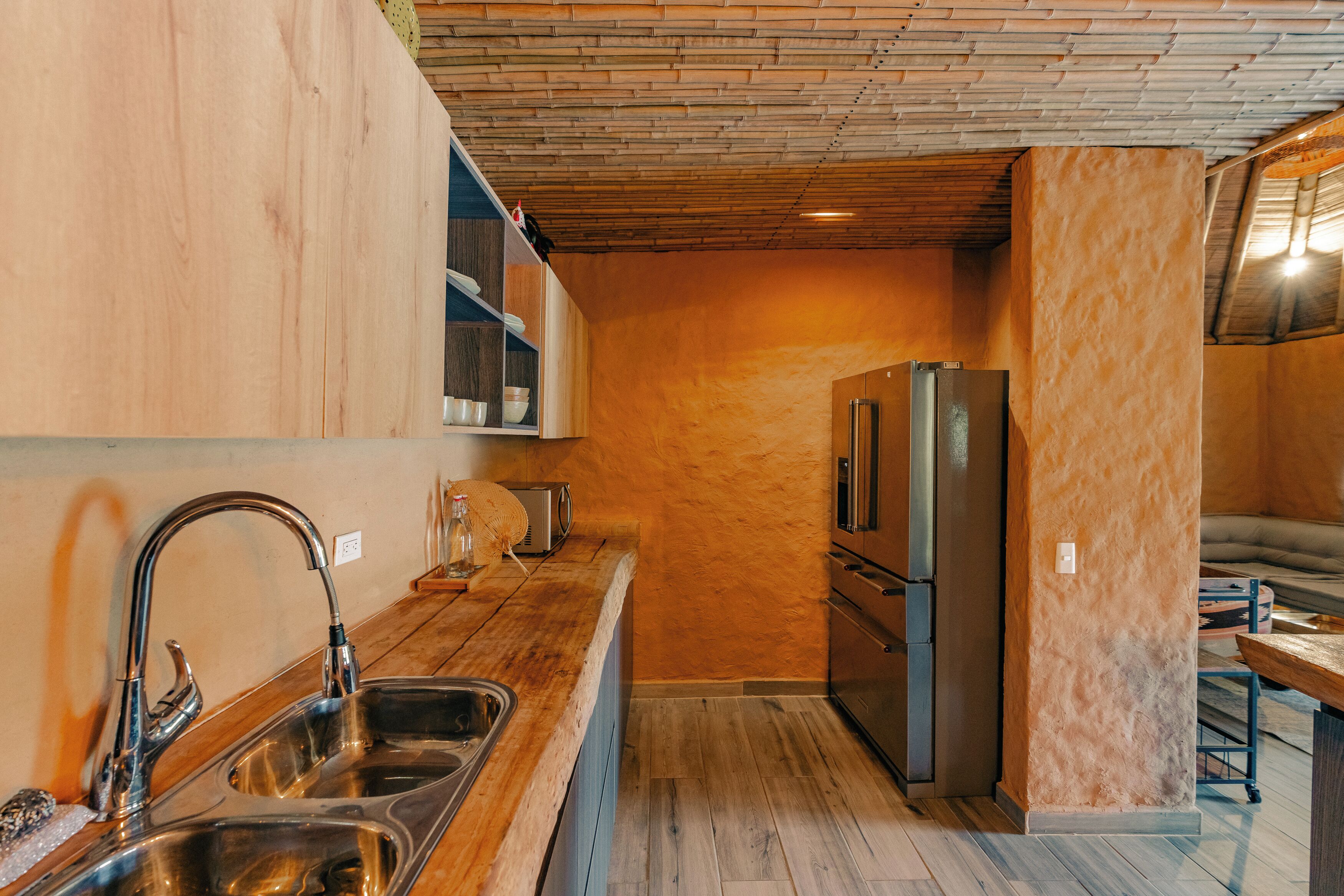 A compact kitchen with a stainless steel sink, a built-in toaster, and a refrigerator.