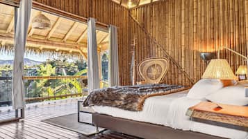 Una habitación con cama, silla, lámpara y vista a zonas verdes.