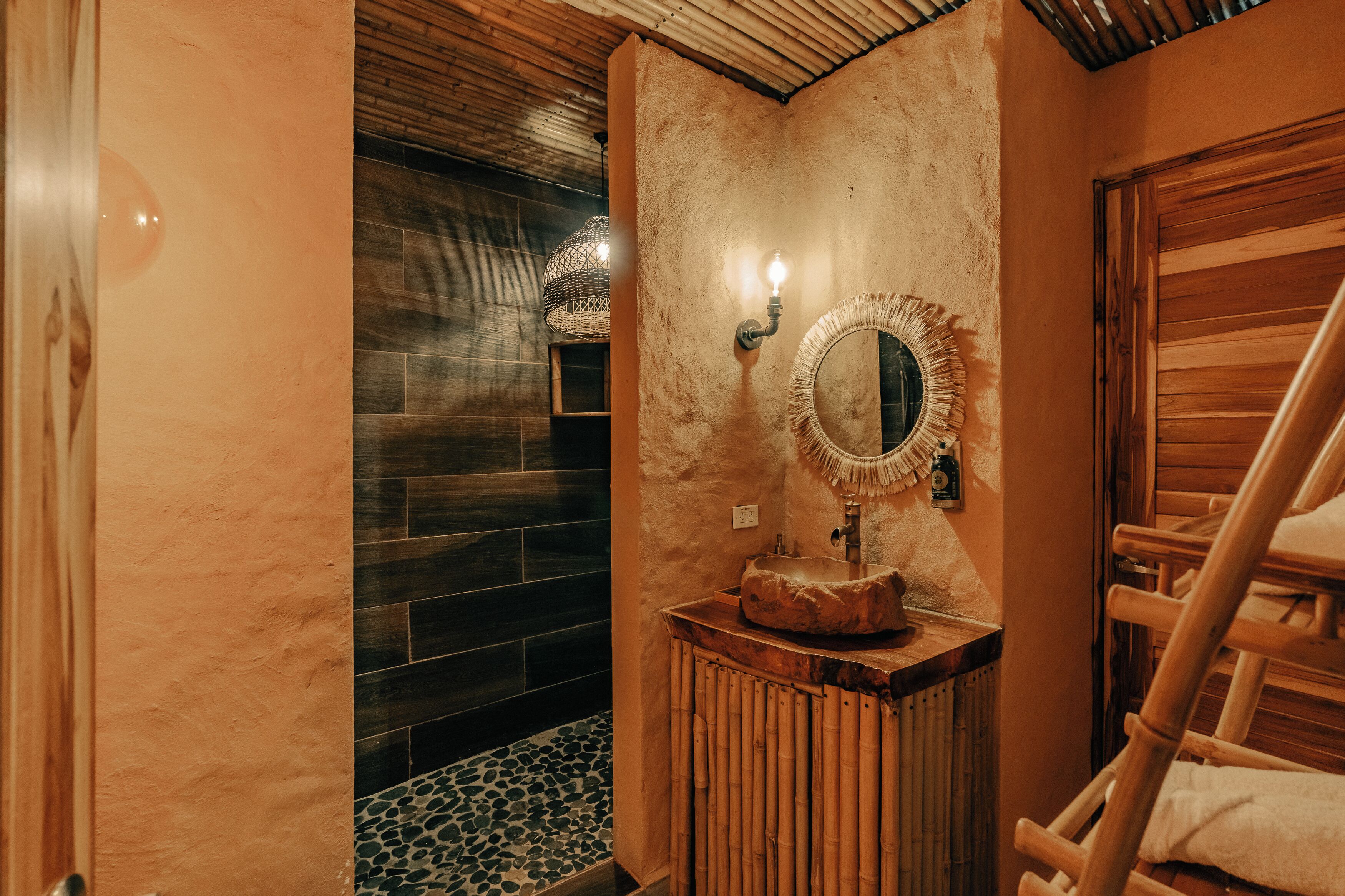 Un bagno con una parete in pietra, un mobile lavabo in legno, uno specchio e un porta asciugamani.