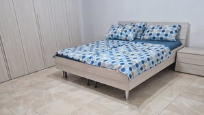 A bedroom with a bed, a nightstand, and a wardrobe.