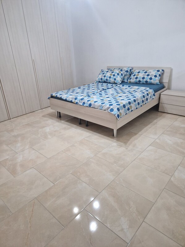 Un dormitorio con cama, mesita de noche y armario.