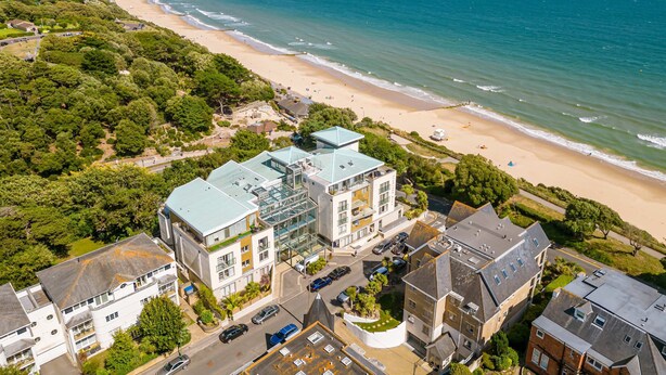 Vue aérienne d’une zone côtière avec des bâtiments, une plage et l’océan.
