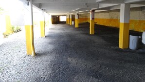 An underground parking garage with concrete pillars and a gravel floor. - Hotel Mirante (Barra Velha)
