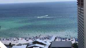 Una spiaggia con vista sull'oceano, una barca e un edificio di un albergo.