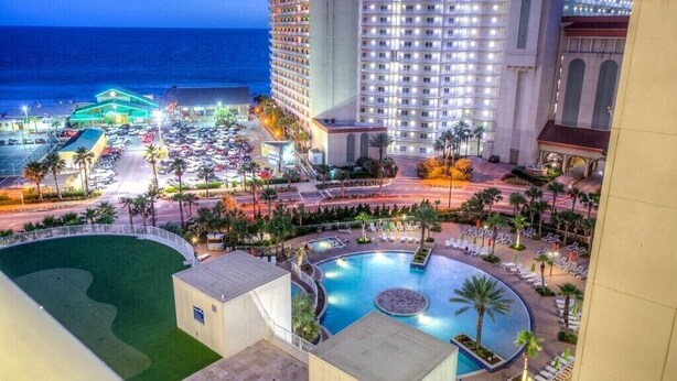 Un hotel con piscina, vista sull'oceano e parcheggio.