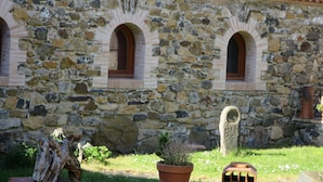 A stone building with three arched windows and a tiled roof. - La Maison des Landes (Gorges)