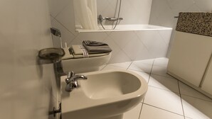 Um banheiro moderno com bidê, vaso sanitário e banheira.