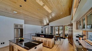 Una cocina moderna con armarios de madera, un refrigerador de acero inoxidable y una isla grande.