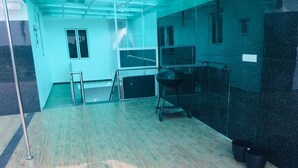 A room with a wooden floor, a black grill, and a metal ladder. - Grand Star Guest House (Batticaloa)