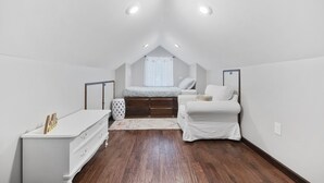 Een slaapkamer met een hoogslaper, een witte ladekast en een klein raam.