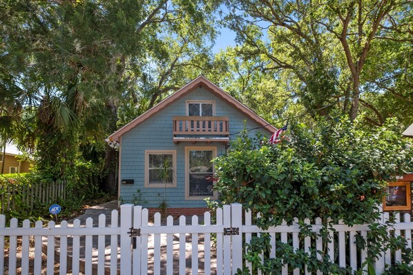 A small, single-story house with a front porch and a small balcony.