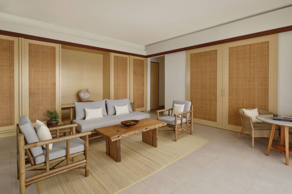 A traditional Japanese-style room with tatami flooring, a low wooden table, and a sofa with cushions.