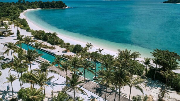 A resort with a large pool, palm trees, and a beach. - Sheraton Belitung Resort (Tanjung Pandan)