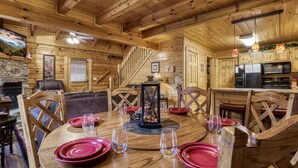 L’intérieur d’un chalet en bois comprend un coin repas, une cuisine et un escalier.