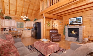 Un acogedor interior de cabaña de madera con sala de estar, cocina y chimenea.