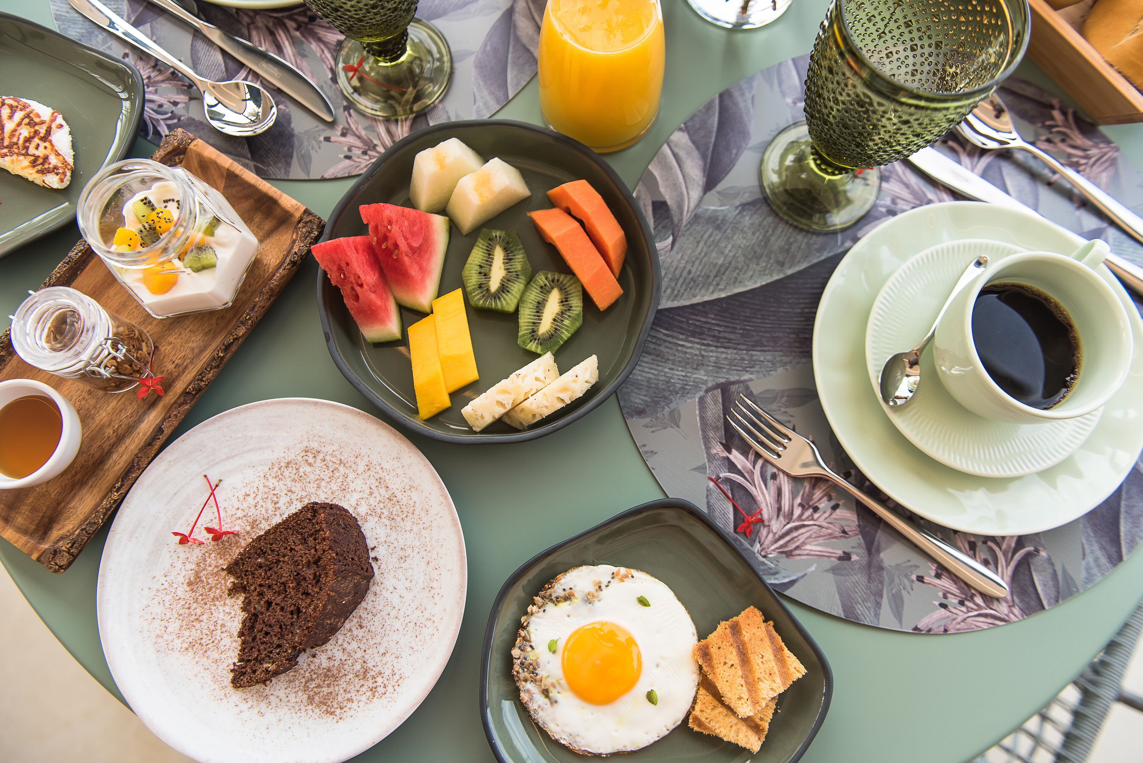 A breakfast setting with various food items and beverages on a table.