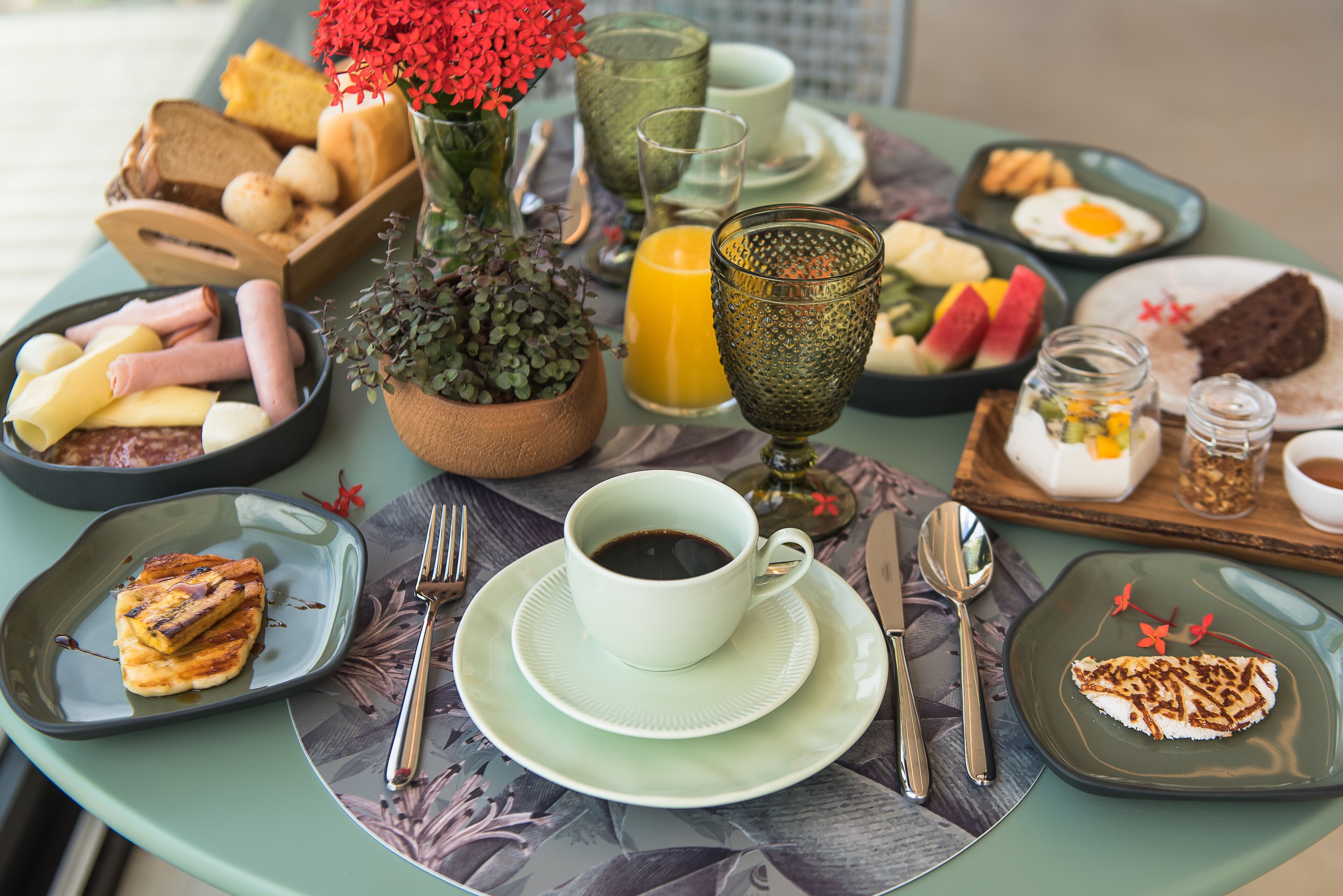 Ein Esstisch mit verschiedenen Speisen, einer Kaffeetasse und einer kleinen Pflanze.