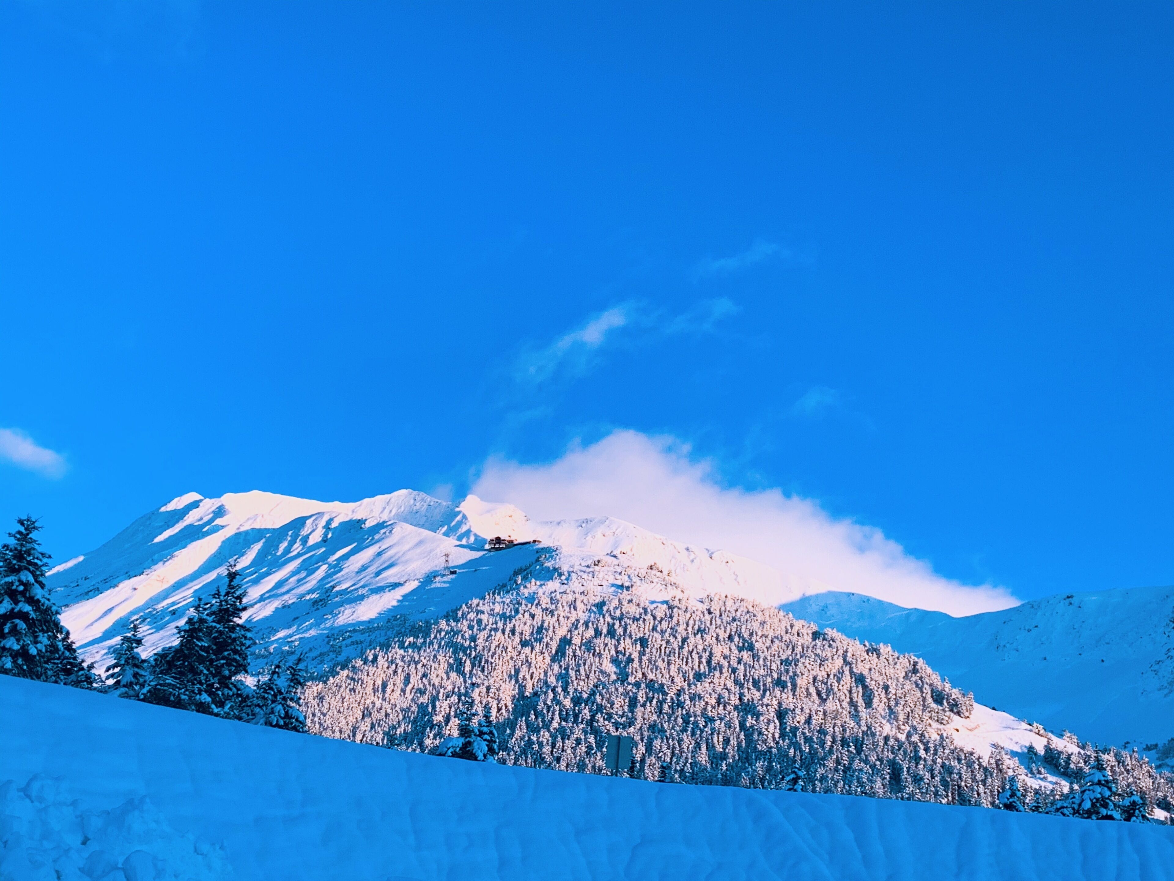 A snow-covered mountain with a clear blue sky.