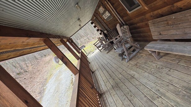 A wooden deck with benches and a picnic table, overlooking a gravel path and trees. - Holler Cabin 4 bedroom Hocking Hills-Tar hollow (price calculated per #  guests) (Laurelville)