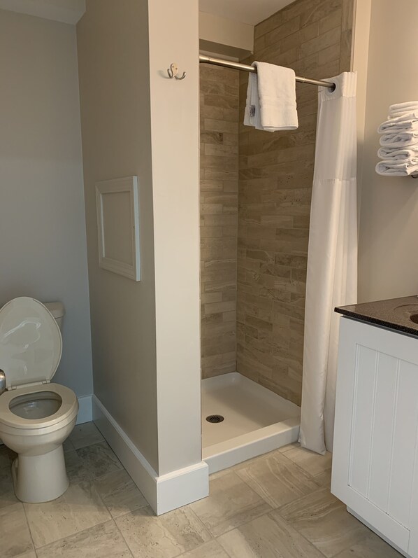 A bathroom with a shower, toilet, and sink.