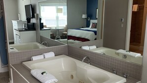 Un baño moderno con una bañera grande, una zona de ducha separada y un tocador con espejo.
