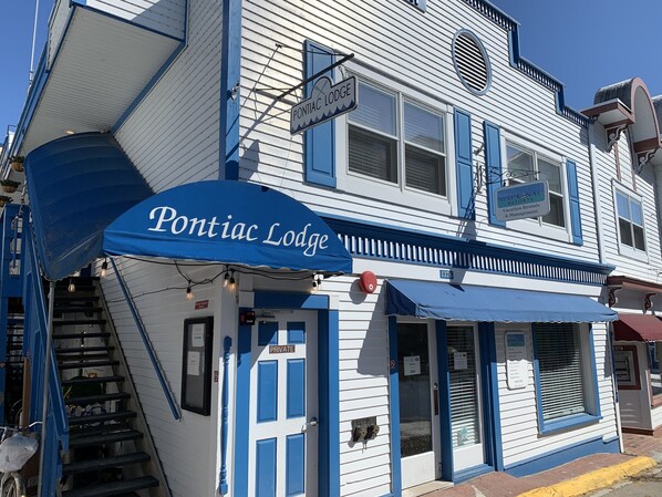 A building with a blue awning labeled "Pontiac Lodge" and a sign for "Blackhawk Resorts Vacation Rentals & Management." - Pontiac Lodge (Mackinac Island)