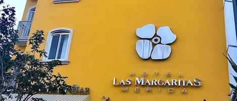 A yellow building with a sign reading "HOTEL LAS MARGARITAS MERIDA".