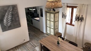 Ein Essbereich mit einem Holztisch, einer Hängelampe und einem Schrank mit Dekorationen.