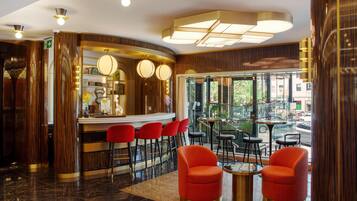 A bar area with red chairs and a counter, a glass door leading outside, and a patterned floor.
