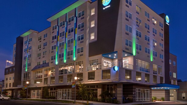A multi-story hotel with a modern design, featuring a prominent 'TRU by Hilton' sign, large windows, and a well-lit facade. - Tru By Hilton St. Petersburg Downtown Central Ave, FL (St. Petersburg)