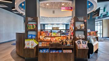A snack kiosk with various packaged snacks and a sign advertising local items.