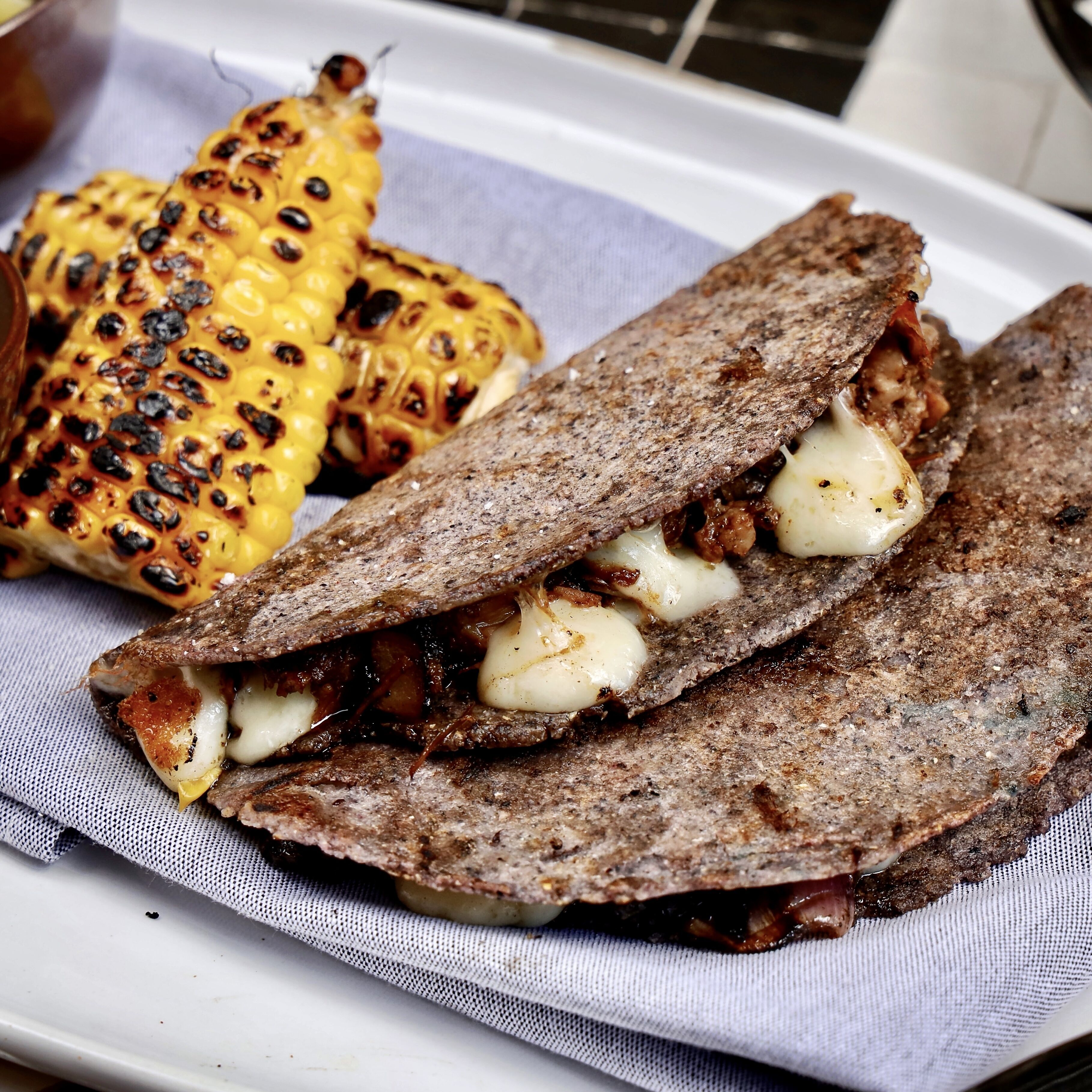 Une assiette de maïs grillé et un sandwich.