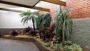 A landscaped garden area with various plants and a brick wall.