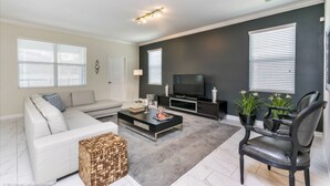 A modern living room with a sofa, coffee table, and TV stand.