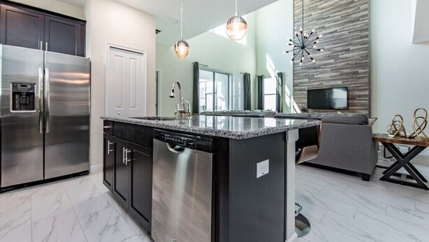 A modern kitchen with a central island, stainless steel appliances, and a built-in dishwasher. - 5 Bedroom 5 Bathroom in Storey Lake 4740shd (Kissimmee)