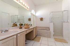 A bathroom with two sinks, a large mirror, a bathtub, and a shower. - Northampaton Villa Highlands Reserve (Davenport)