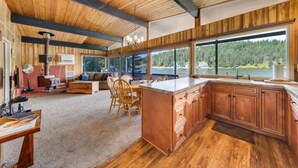 Un'ampia cucina con mobili in legno, una grande isola e vista su un lago.