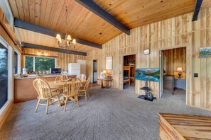 L’intérieur d’un chalet rustique comprend un coin repas, une cuisine et un espace de vie.