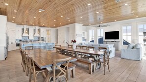 Un'ampia cucina con soffitto in legno, un grande tavolo da pranzo e un forno a incasso.