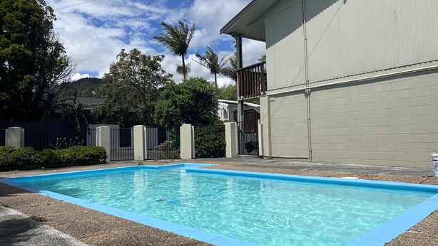 A swimming pool with a blue edge, surrounded by a concrete deck.