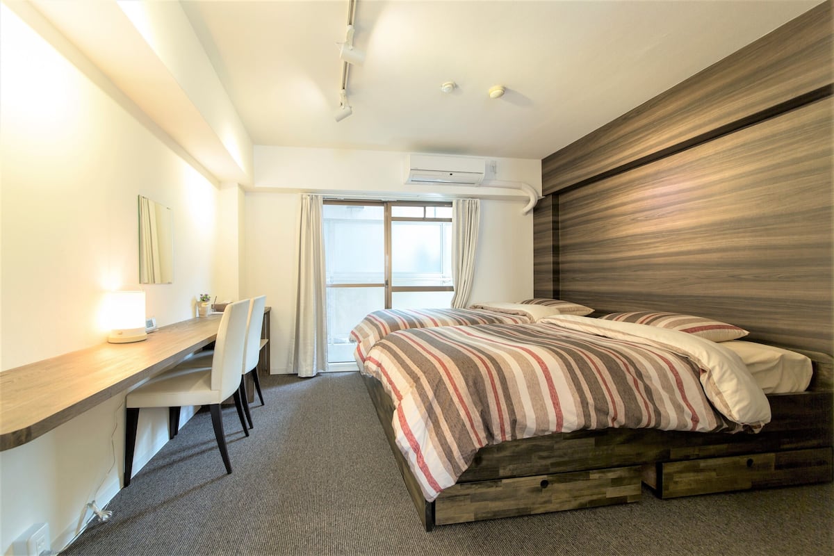 A bedroom with a bed, a desk, and a chair.