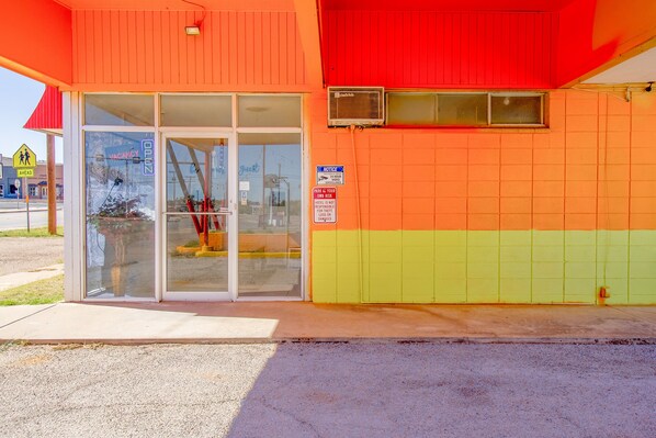 A building with a glass door, a 'VACANCY OPEN' sign, and a 'NOTICE: PARK AT YOUR OWN RISK' sign. - Wheeler Inn Texas, Us - 83 By OYO (Portland)