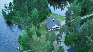 An aerial view of a lakeside property with a house, dock, and surrounding forest. - Suvituuli by Interhome (Pertunmaa)