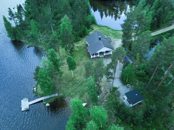 An aerial view of a lakeside property with a house, dock, and surrounding forest. - Suvituuli by Interhome (Pertunmaa)
