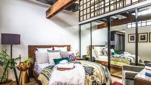 A bedroom with a large bed, a mirror, and a red rug. - Historic DC Firehouse Penthouse Loft (Washington)